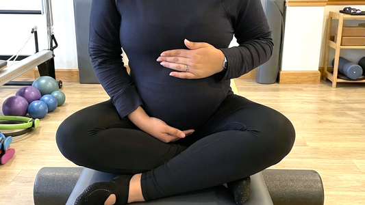 Sesión de Pilates para salud reproductiva y fertilidad en Panamá. Mujer embarazada en su práctica en su clase de Pilates